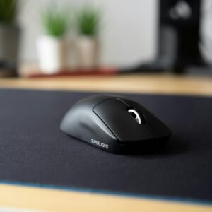 Sleek black wireless mouse on a modern desk with a blurred background, emphasizing minimalism.